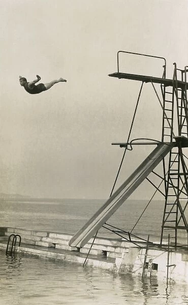 Man diving into an outdoor pool at a seaside resort