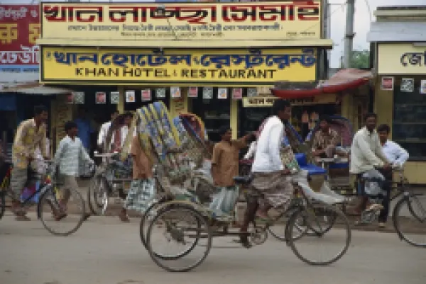 Buy Men riding cycle rickshaws on the street passing the