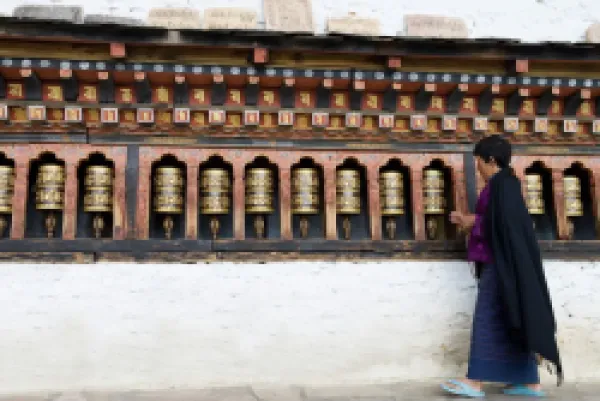 Buy Bhutanese woman turning Buddhist prayer wheels