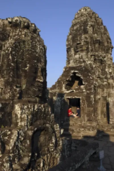 Buy A couple rest beneath the giant faces of the Bayon temple
