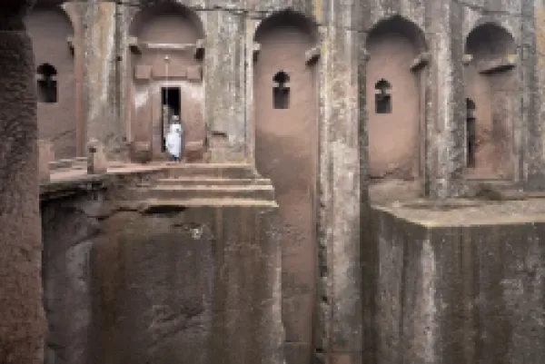 Buy A priest stands at the entrance to the rock-hewn church