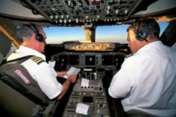 Buy Pilots on flight deck of Jumbo Boeing 747 of Air New Zealand with sunrise ahead