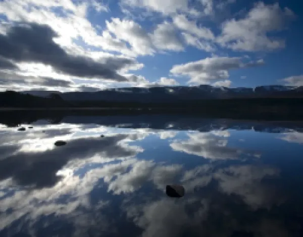 Buy Scotland, Scottish Highlands, Cairngorms National Park. Dramatic clouds and Cairngorm mountains reflected upon the still face of Loch Morlich.