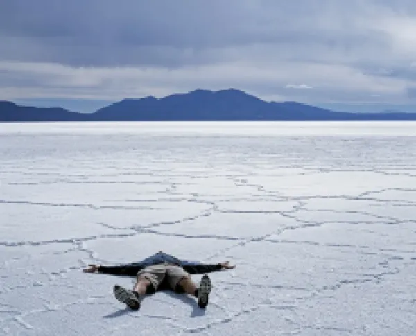 Buy A tourist lies on the salt crust of the Salar de Uyuni