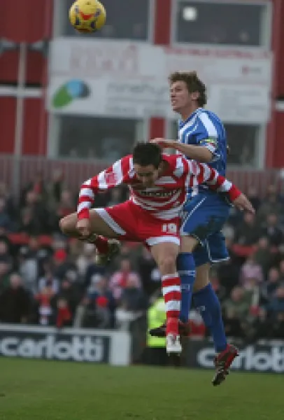 Dean Hammond wins the ball in the air against Brian Stock