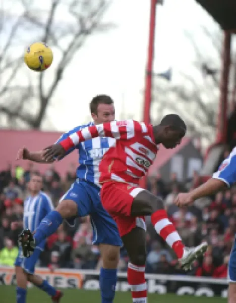Adam Hinshelwood in an aerial challenge with Jonathan Forte