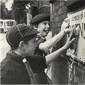 Boy Scouts cleaning street sign, London