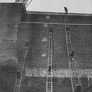 Firefighters climbing wheeled escape ladders