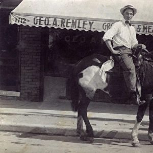 Man on horseback outside a shop, USA