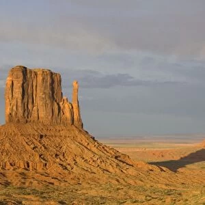 USA - The shadow of West Mitten Butte crawls up East Mitten Butte, the two most prominent and photogenic landmarks of the Monument Valley, the classic Wild-West landscape of sandstone buttes