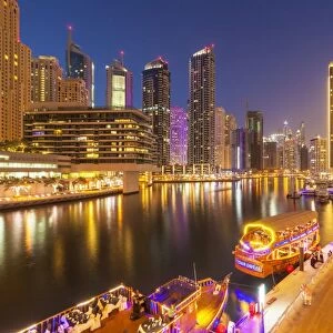 Dubai Marina skyline and tourist boats at night, Dubai City, United Arab Emirates