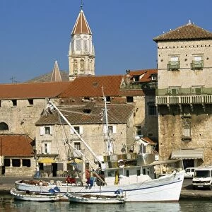 Fishing boats in harbour, with houses and tower beyond in the town of Trogir