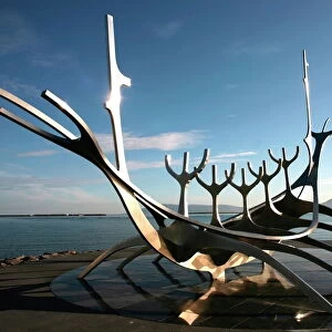 The midnight sun lights up the giant steel boat sculpture that stands on the waters edge at Reykjavik, Iceland