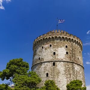 View of the citys landmark The White Tower, with Greek flag waving on top, Thessaloniki