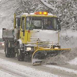 A snow plough driving in heavy snow in Ambleside UK