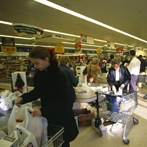 Shopping, Supermarket, Interior of Safeways supermarket in Bearsted, Kent, Shoppers packing trolleys at the checkout with lines of stacked shelves behind