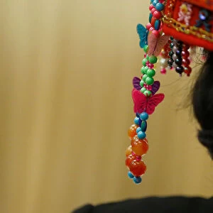 A woman wears traditional headgear during a session of the Hainan province at the