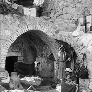 BETHLEHEM: HOME, c1928. A family outside a stone home in Bethlehem. Photograph, c1928