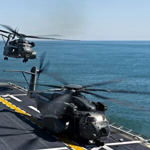 MH-53E Sea Dragon helicopters take off from the flight deck of USS Wasp