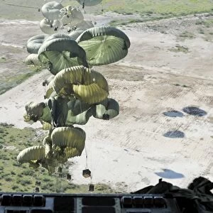 Pallets of relief supplies are air delivered from a C-17 Globemaster III over Haiti