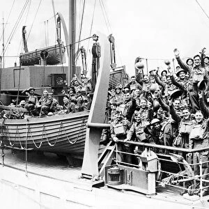 British Soldiers smiling and waving on board a troop ship as they sail to join