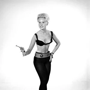Model Brenda Bartlet dressed as Bond girl holding gun. October 1959