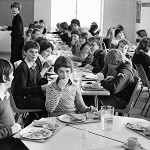 Pupils enjoying their school dinners in a packed dining hall