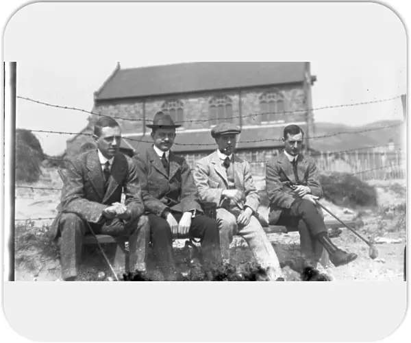 Four men on a bench at golf club