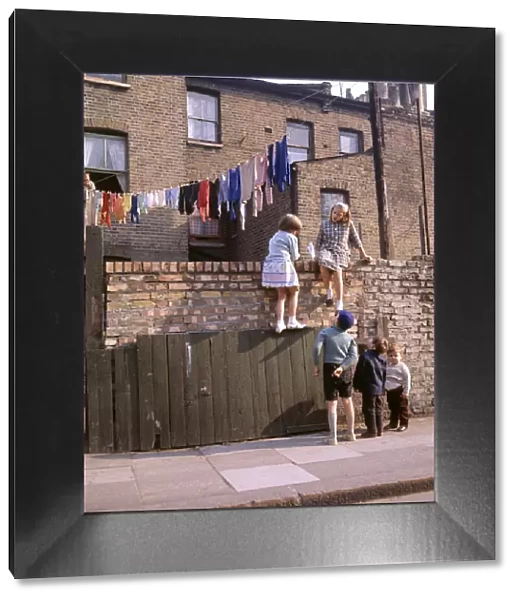 Chldren on a wall, with washing, Balham, SW London
