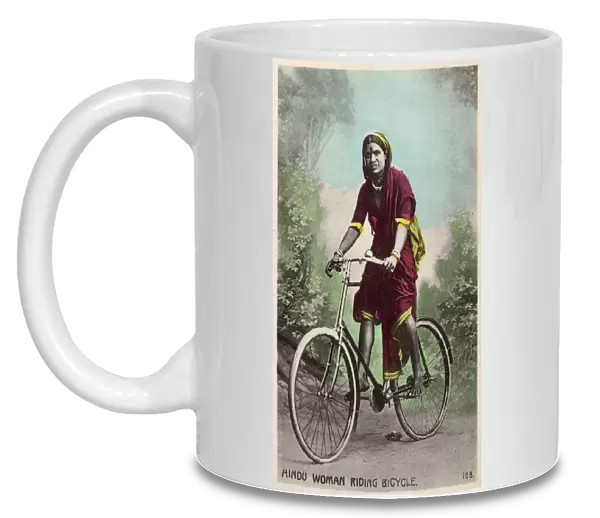 Studio portrait, Hindu woman riding a bicycle, India