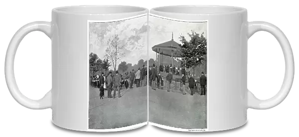 Crowd listening to live music on the bandstand in Battersea Park, London. Date: late 1890s
