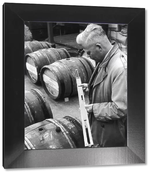 Customs Official checks the volume of wine in a barrel