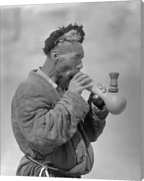 A Uyghur man smoking an elaborate pipe