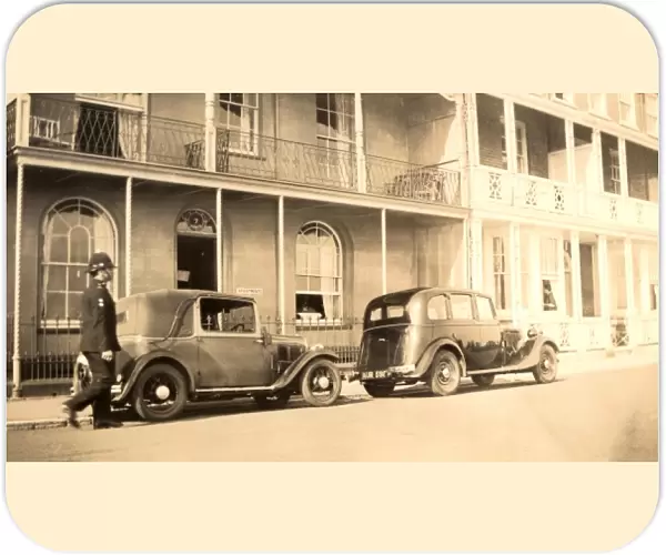 Policeman and parked late 1920s cars