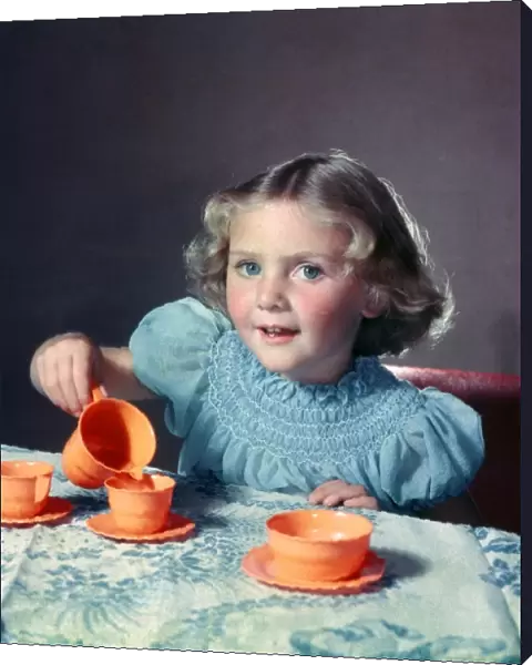 Little Girl playing with toy tea set