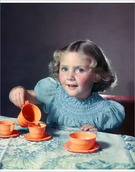 Little Girl playing with toy tea set