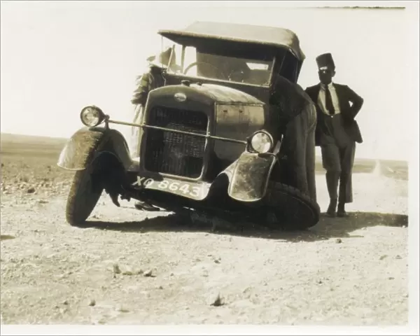Car with broken wheel in the desert, Middle East