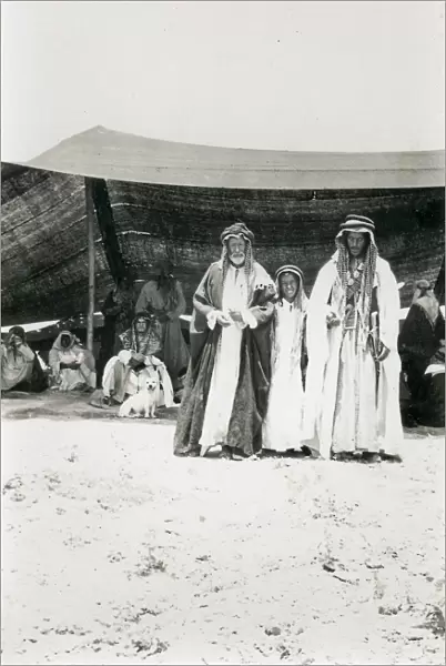 Two Bedouin men and a boy outside a tent, Middle East