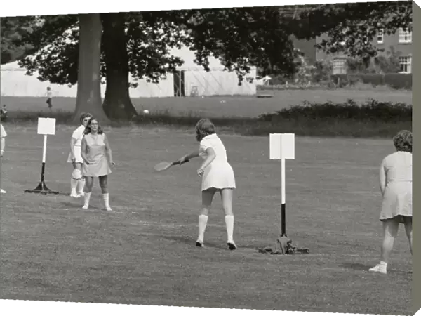 Five people playing a ball game in a field