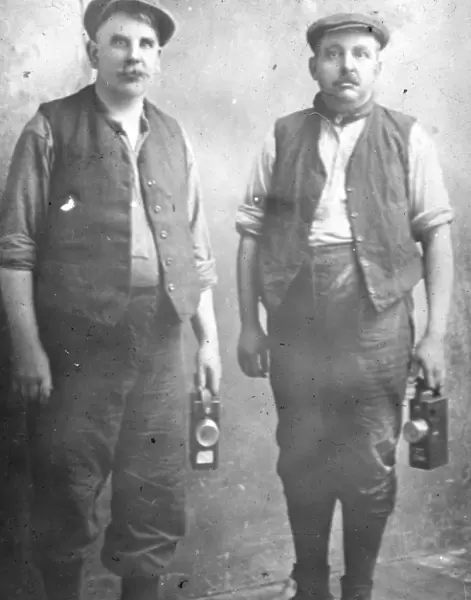Two middle aged miners with their lamps, South Wales