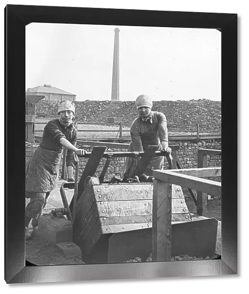 Two women emptying a coal truck