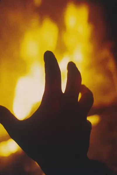 FIRE. A hand hovering over a burning flame! Date: 1971