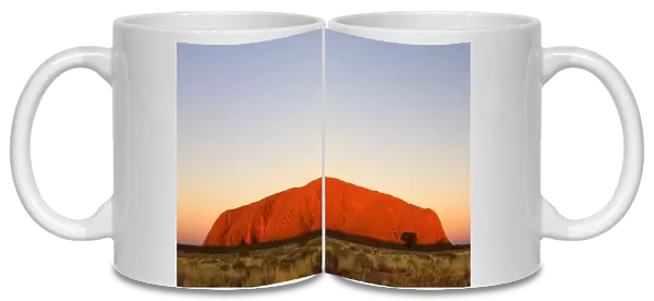 Australia - Ayers Rock - Uluru - brightly ablaze Ayers Rock at sunset - Uluru-Kata Tjuta National Park, World Heritage Area, Northern Territory. Aboriginals of the Anangu tribe call Ayers Rock Uluru