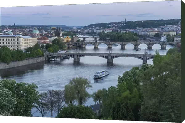 Prague cityscape looking down the Vltava River at its bridges connecting the Old