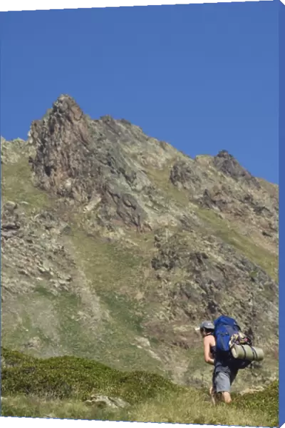 Hiker on climbing trail in hiking area of Pic de Coma Pedrosa, Andorras highest mountain