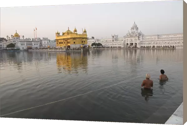 Two Sikh pilgrims bathing and praying in the early
