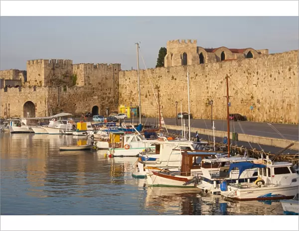View across tranquil Kolona Harbour to the city walls, sunrise, Rhodes Town, Rhodes