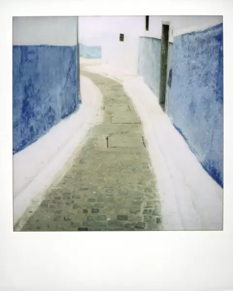 View taken on Polaroid down narrow street showing traditional