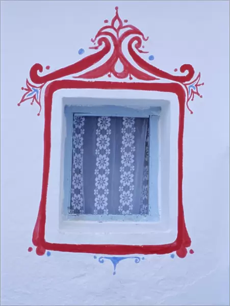 Decorated window in a white wall