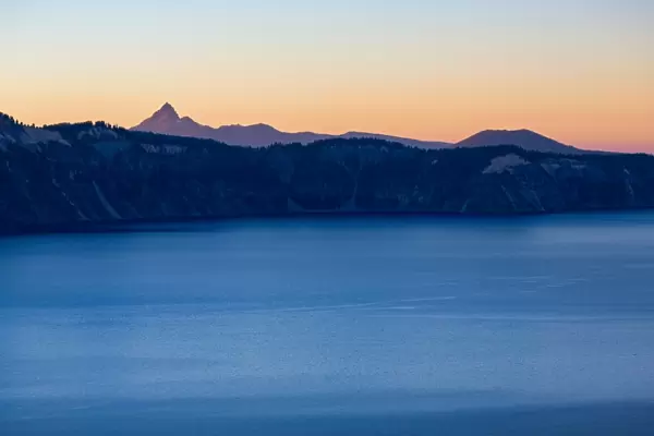 Dusk over the still waters of Crater Lake, the deepest lake in the U. S. A. with Mount Thielsen